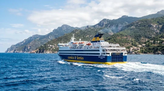 Un ferry Corsica Ferries naviguant en pleine mer Méditerranée sous un ciel bleu éclatant, vue extérieure du navire depuis la mer